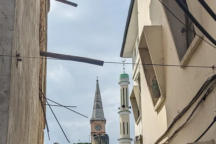 Blick auf einen Kirchturm und das Minarett einer Moschee.