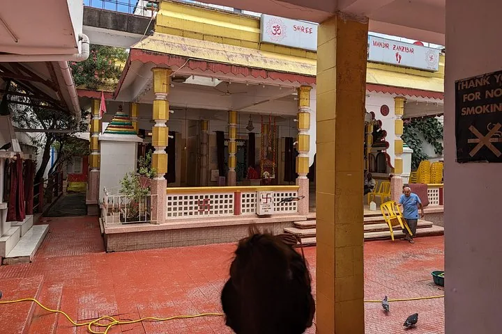 Eine Person steht im Innenhof eines hinduistischen Tempels.